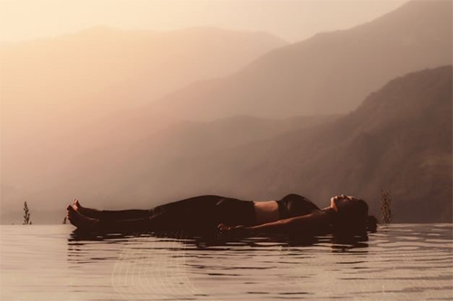 Woman meditating on a beach